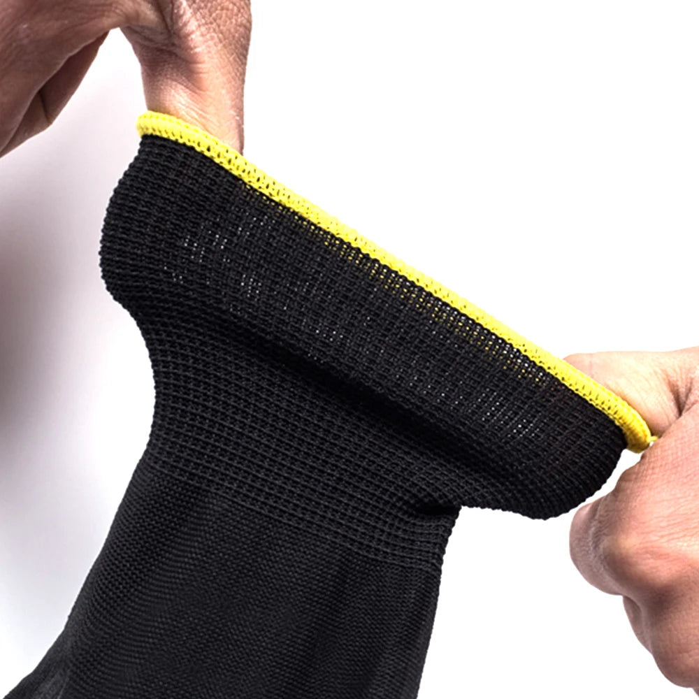 Black sock with yellow trim held by a hand against a white background